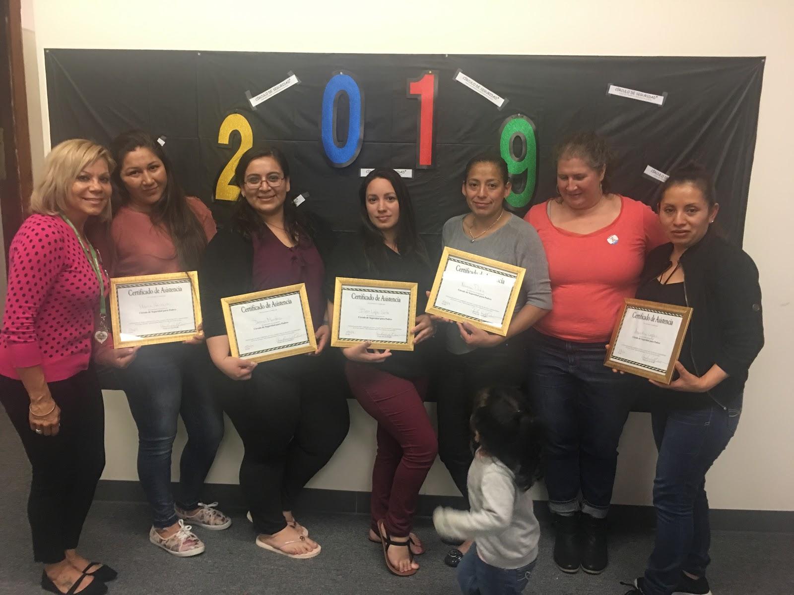 Family Child Care educators Maria Amado and Rosa Bodden posing with foster parents who have just completed a COSP group at All Our Kin.